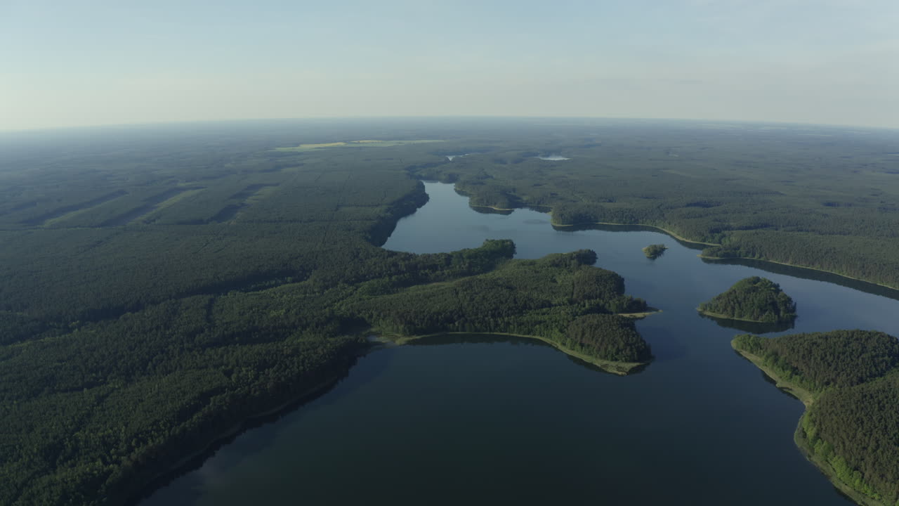 Aerial panoramic overview of lake water surrounding islands and forests in Drawieński National Park, tranquility and natural beauty