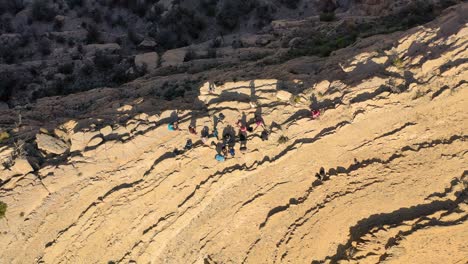 Una-Foto-Superior-De-Un-Grupo-De-Personas-Haciendo-Turismo-En-Un-Acantilado,-Omán