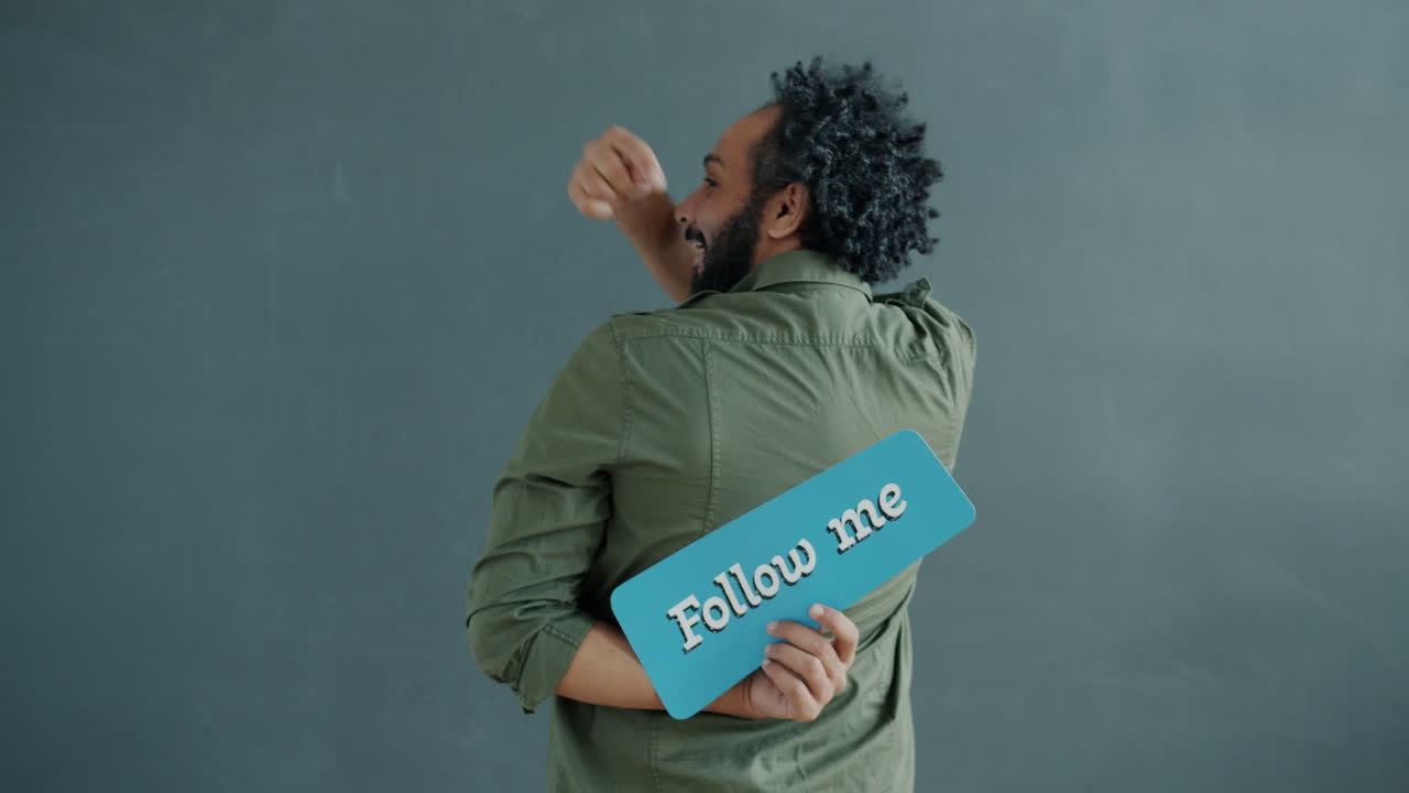 Man Holding Up a 'Follow Me' Sign