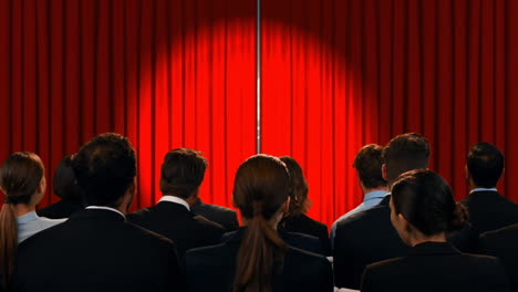 personas de negocios en un teatro viendo palabras alentadoras