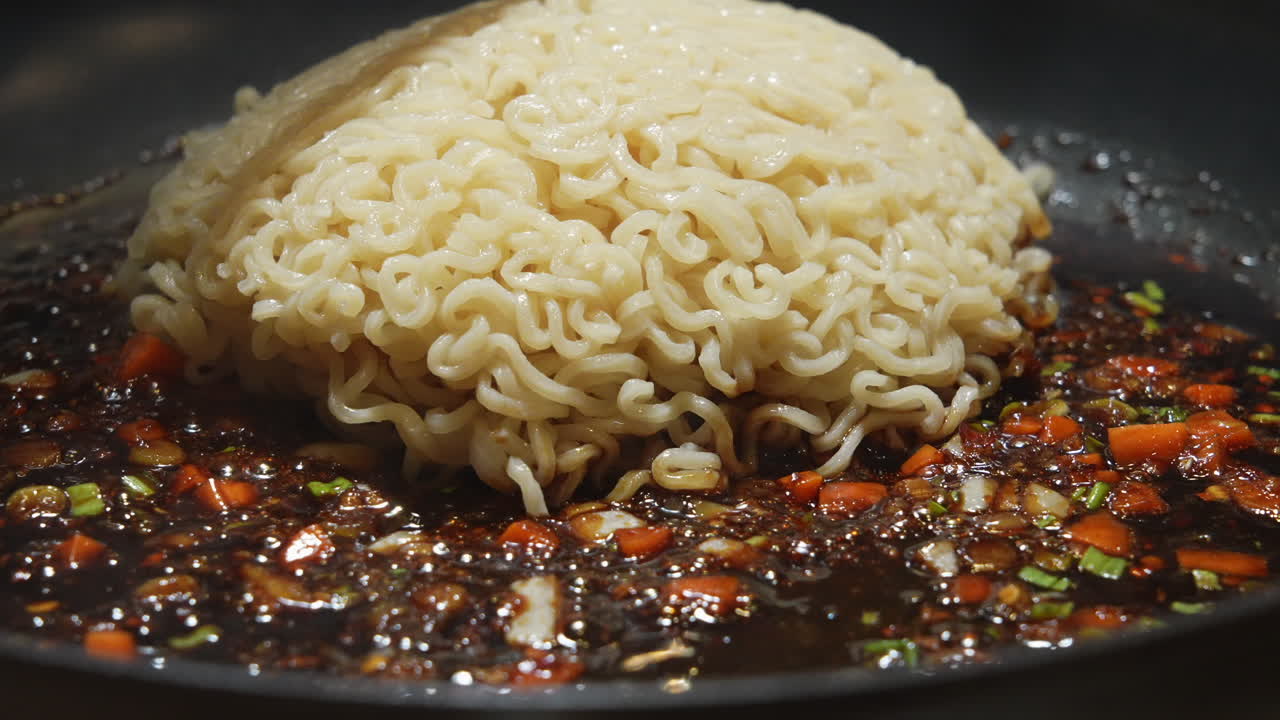 Dumping ramen noodles in sizzling saut&eacute; sauce