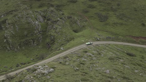 Personas-A-Bordo-De-Un-Coche-Antiguo-Descapotable-Conduciendo-Por-Una-Estrecha-Y-Sinuosa-Carretera-De-Montaña,-Pirineo-Vasco,-Col-Inharpu-En-Francia