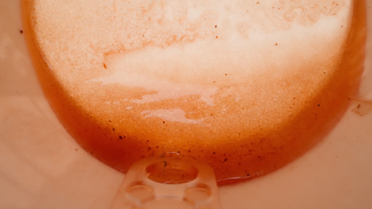 restos de café y azúcar en taza con palillo de plástico