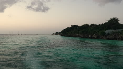 Zeitlupenaufnahme-Vom-Boot-An-Der-Wunderschönen-Küste-Sansibars-Bei-Sonnenuntergang,-Sommerkonzept,-Unbeschwerter-Urlaub,-Afrika,-Tansania