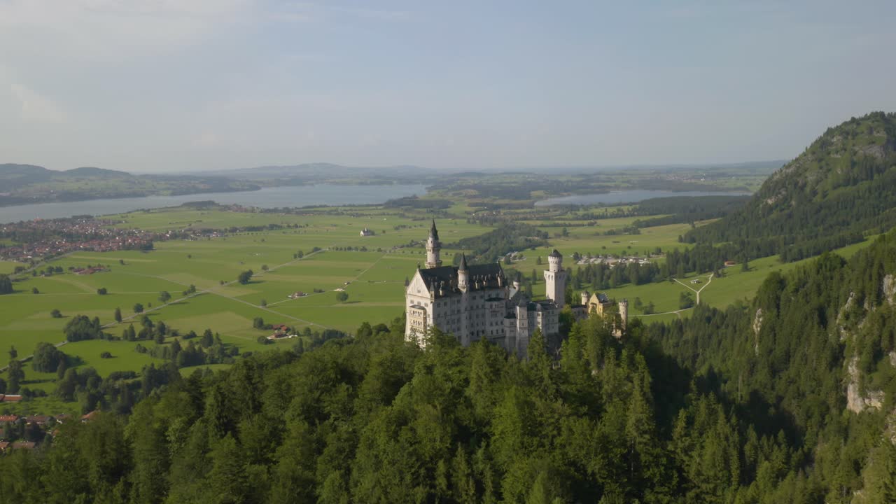 toma aérea ascendente revela el castillo de neuschwanstein en un pintoresco día de verano en baviera, alemania