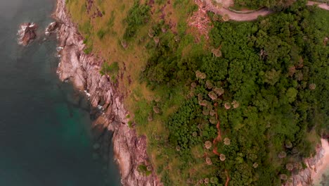 Overhead-aerial-drone-shot-of-Kanchanaphisek-lighthouse-at-Laem-Promthep-Cape,-at-the-tip-of-Phuket-island-in-the-Southern-part-of-Thailand