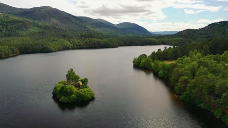 above the pines: loch an eilein and castle's aerial spectacle, nestled in aviemore's scots pine forest, scottish highlands, uk