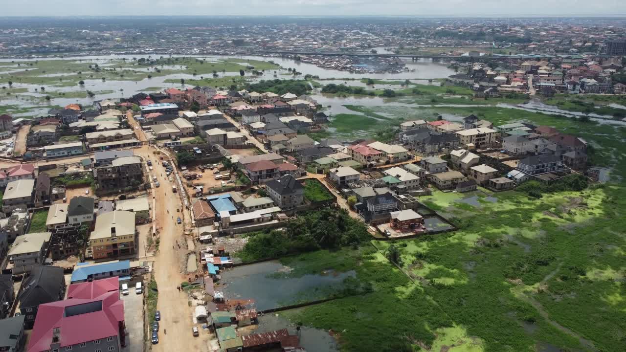 A landlocked swampy slum community near Lagos, Nigeria with view of a long bridge