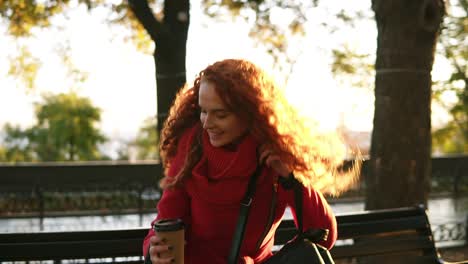 Woman-walking-by-city-park-with-coffee-	ogo"-and-bag"