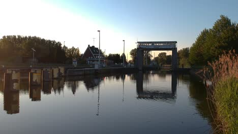 Water-lock-and-buildings-during-golden-hour-in-low-angle-drone-view