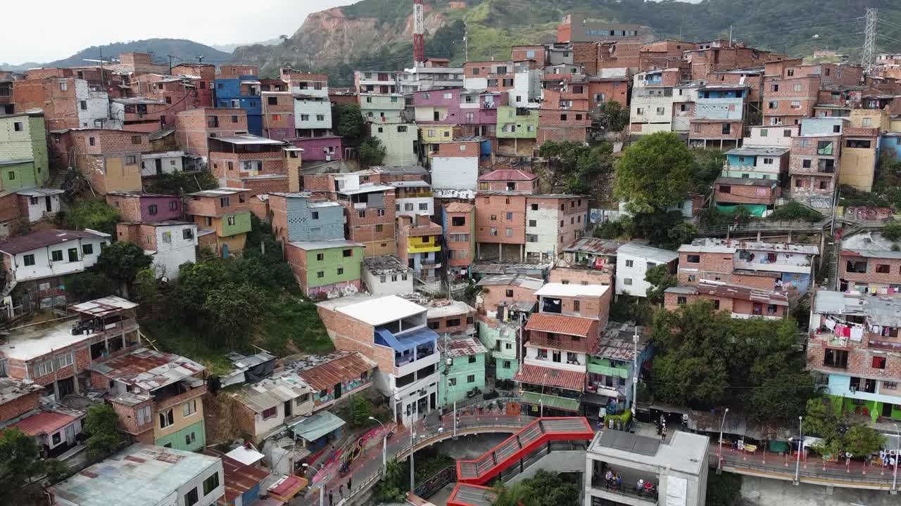 Tomada aérea ascendente de comunidade de favela em encosta íngreme em cidade montanhosa