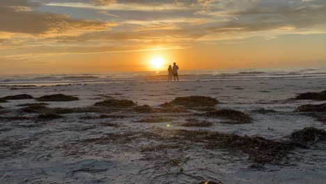 timelapse of couple on the beach watching the sunset at st