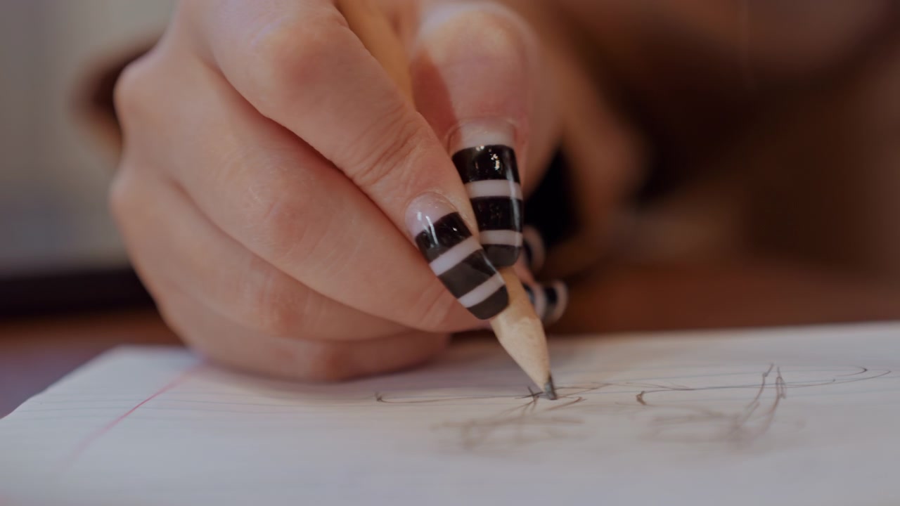 Disegno a mano dettagliato. Studente che disegna con illuminazione delicata. Primo piano di una mano che crea linee a matita con uno sfondo morbido. Rappresentazione artistica di una mano che disegna con luce calda e sfondo sfocato.