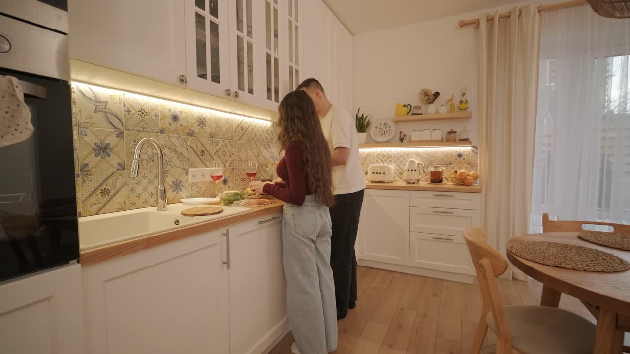 una pareja enamorada haciendo un sándwich en la cocina de la sala de estar