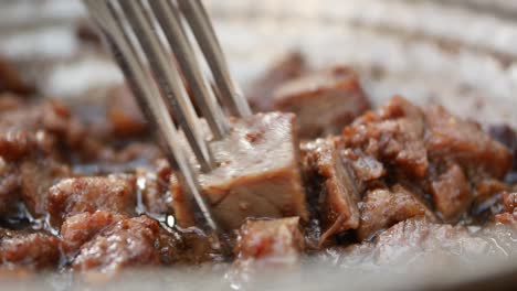 close-up of fork holding a piece of cooked meat