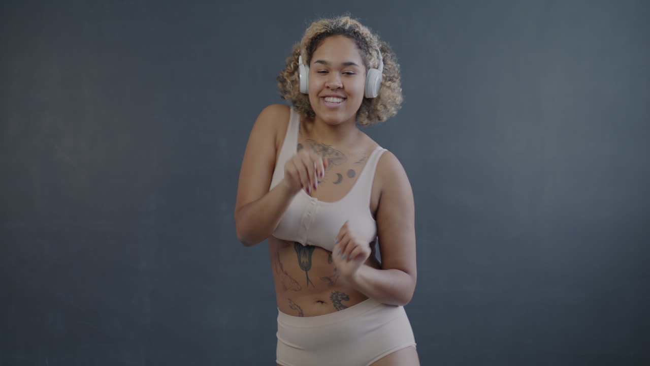 mujer feliz bailando con auriculares