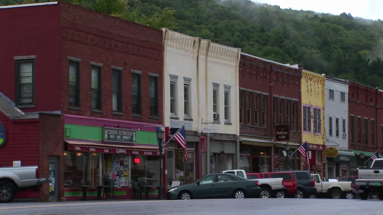 차량은 시내를 운전하고 버몬트의 오래된 벽돌 상점을 통과합니다. 1