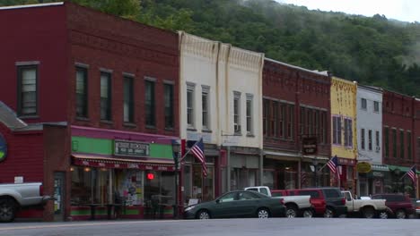 Fahrzeuge-Fahren-In-Die-Innenstadt-Und-Passieren-Alte-Backsteinläden-In-Vermont-1