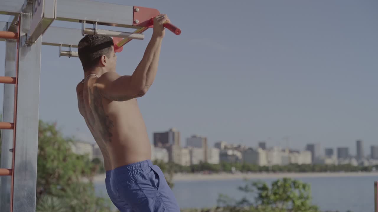 Man Performing Pull-ups on Outdoor Fitness Equipment