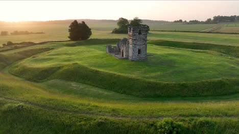 Vista-Aérea-De-Bajo-Nivel-De-La-Iglesia-De-Knowlton-Al-Amanecer,-Dorset,-Inglaterra