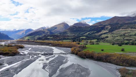 aerial footage captures glenorchy's braided river and lush valleys under dynamic skies, showcasing new zealand's stunning natural beauty