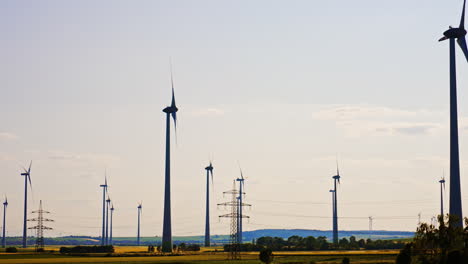 silhouettes of mind turbines in the vast field. electric power supports are nearby. energy concept.