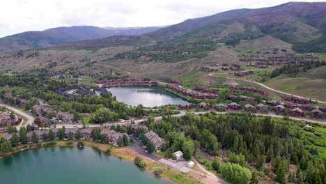 aerial video of ponds near silverthorne, colorado. camera rises up revealing a second pond and houses.