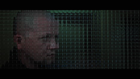 a bald dangerous looking man checks the corridor through reinforced glass