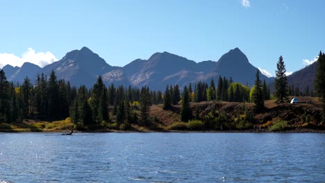 mujer recogiendo en el lago molas de las montañas de san juan en colorado