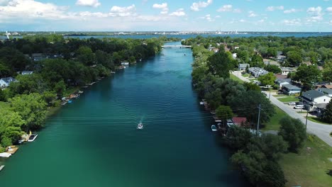 antena épica de montar en bote en el río canadiense durante un día nublado con un patrón en el río rodeado por un pequeño pueblo