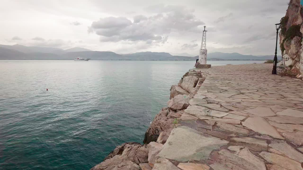 Distant cruise ships anchored off Greek Bouritz bay coastal path Nafplion