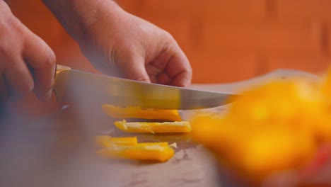 a simple knife cutting of a yellow pepper then puting in a recipient