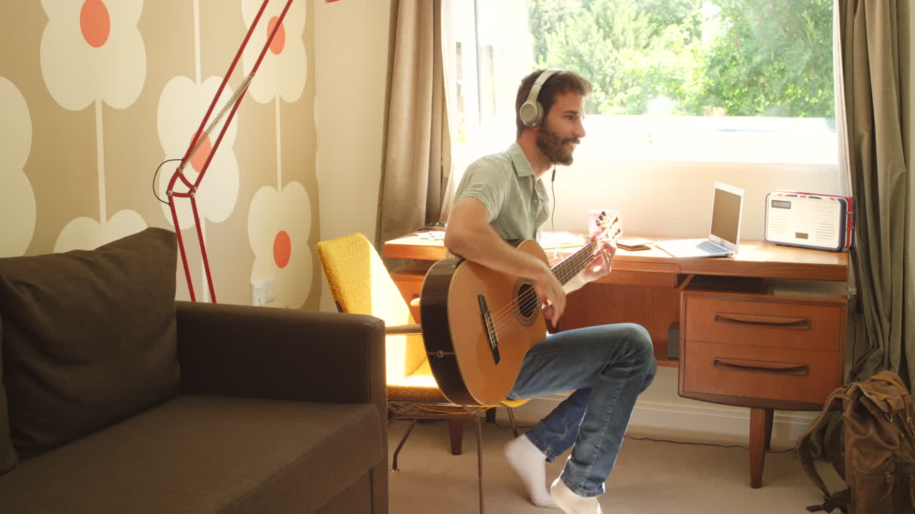 hombre tocando la guitarra en un acogedor estudio casero