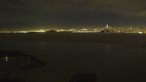 lapso de tiempo del centro de san francisco sobre las aguas del océano pacífico con el puente de la bahía de oakland en el fondo ubicado en california