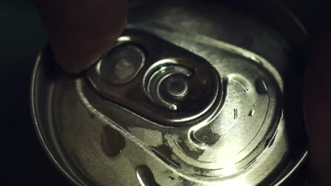 fingers opening a cold can of soda, soft drink