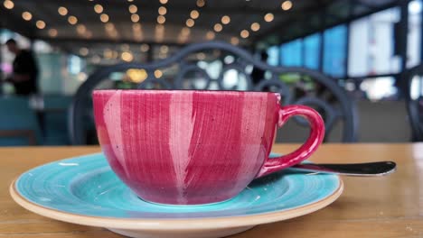 taza de café rosa en una cafetería