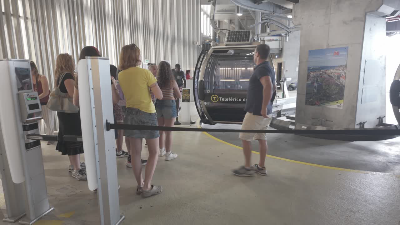 Tourists wait in line for the Porto cable car in Vila Nova de Gaia, sunny day, modern station