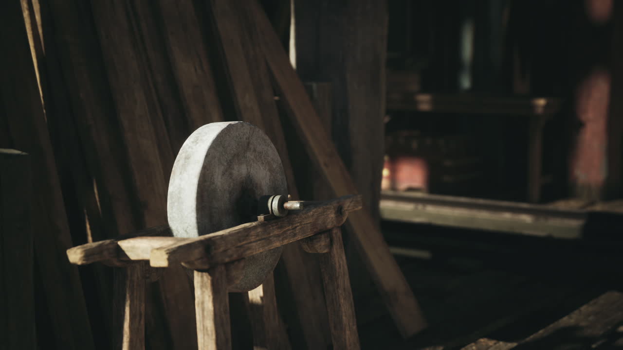 A rustic stone grinding wheel on a wooden stand in a cozy workshop setting