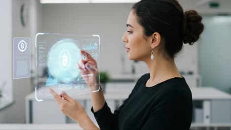 woman interacting with futuristic cryptocurrency interface, displaying financial data and transactions in a modern work environment