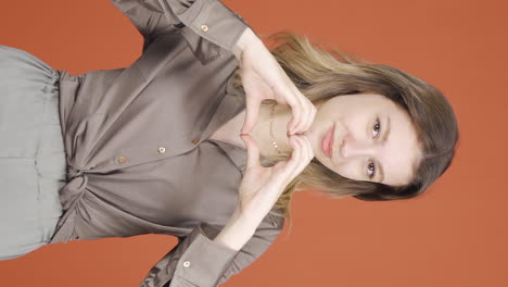 Vertical-video-of-Young-woman-looking-at-camera-making-confidence-sign.