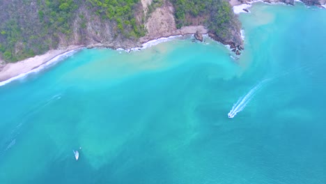 Flying-high-above-a-speed-motor-cruising-past-a-tropical-island-in-the-Tortuga-Islands-in-Costa-Rica