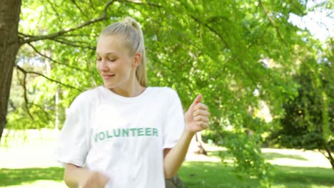 una bella voluntaria rubia bailando y sonriendo a la cámara