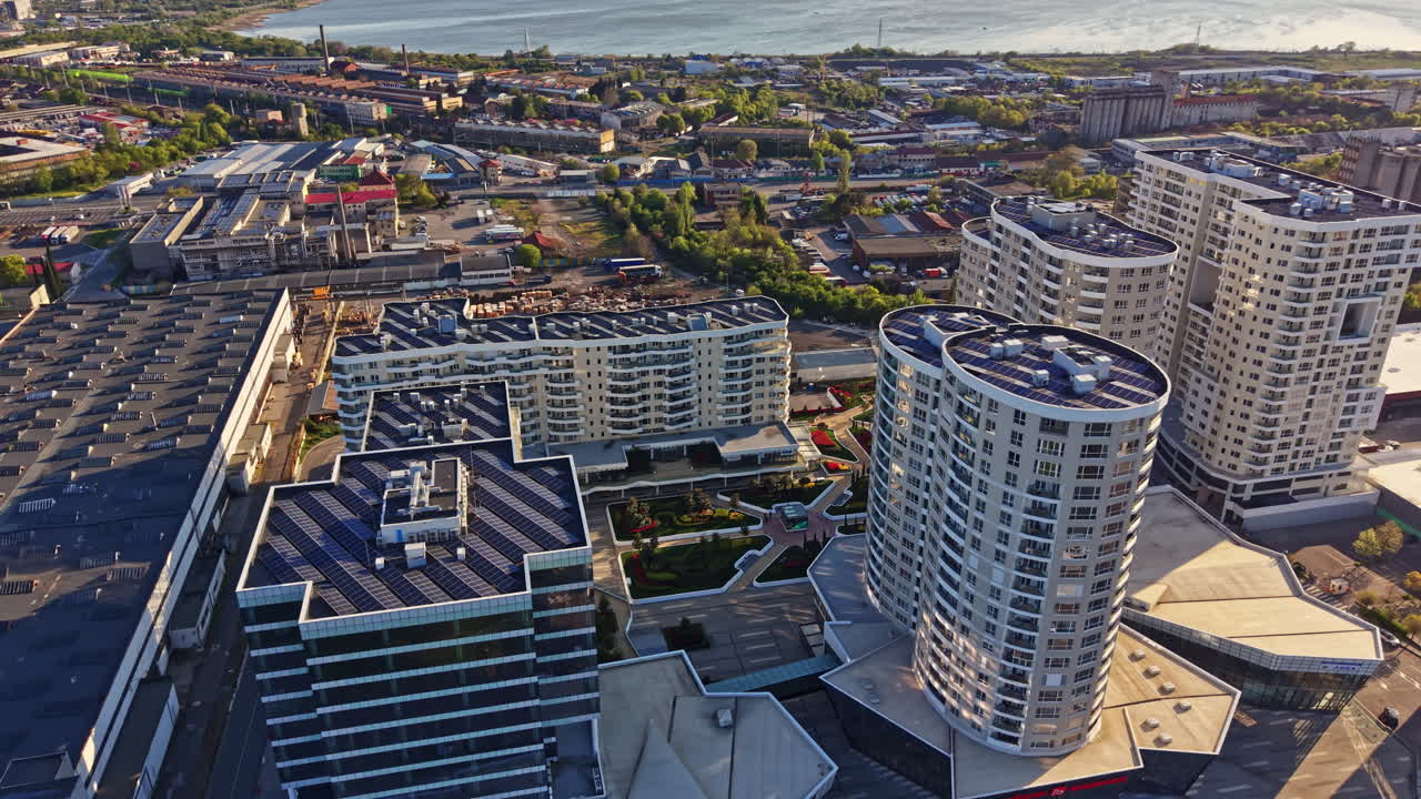 Utsikt över moderna byggnader och stadsmiljö vid vatten under dagtid, med synliga vägar och strukturer.