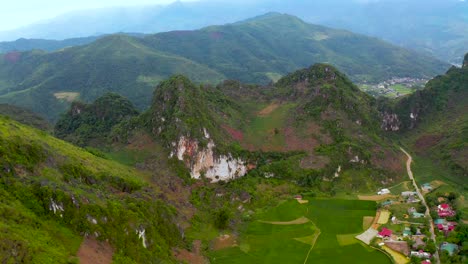 Part 1 - A slow aerial dolly forward over a mountain to reveal a small Vietnamese farm community