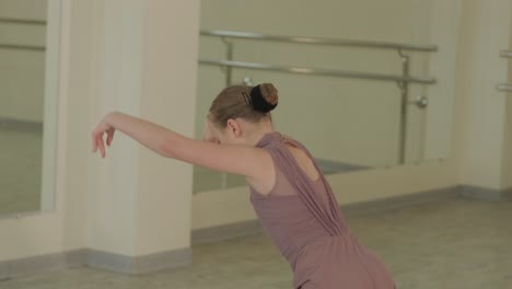 un grupo de jóvenes estudiantes de ballet con ropa de baile negra practicando posiciones en un amplio estudio de ballet con pisos de madera y barras montadas en la pared. expresiones enfocadas y movimientos sincronizados.