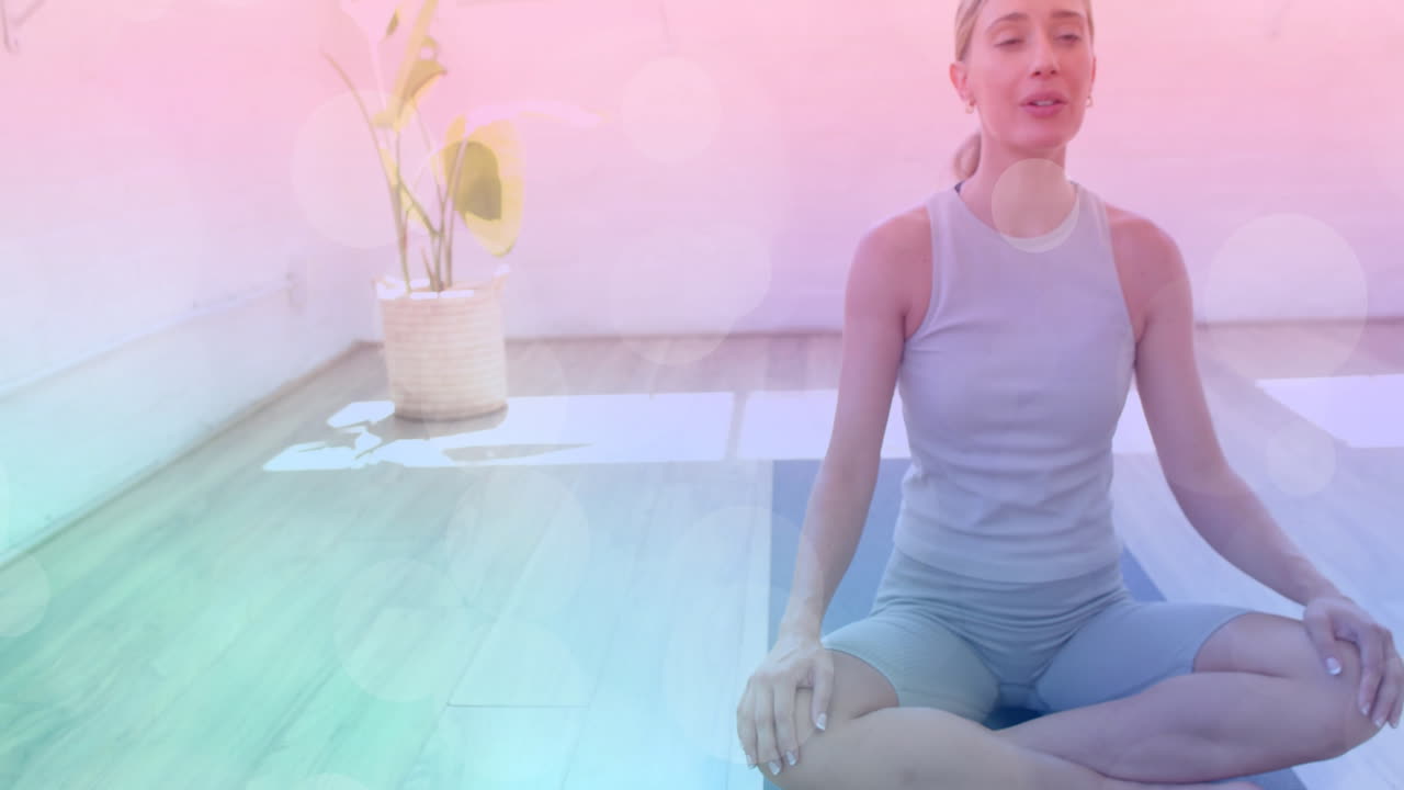 Donna che medita su un tappetino da yoga, si rilassa con uno sfondo bokeh rilassante.