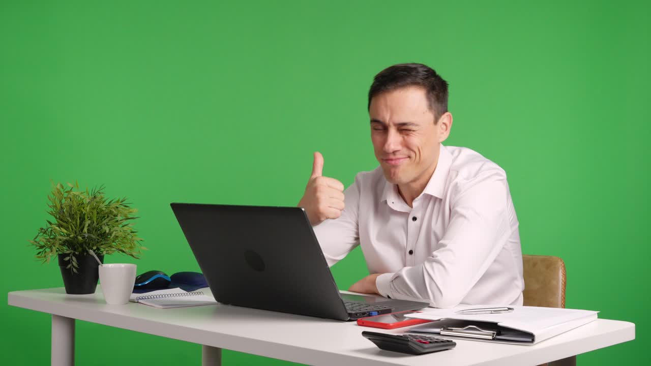 Office worker smiling and giving thumbs up on green screen