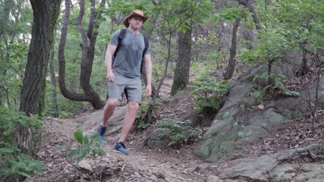 Male-Hiker-climbs-down-A-Rocky-Mountain-With-Narrow-Path---Medium-Shot,-hiking-concept