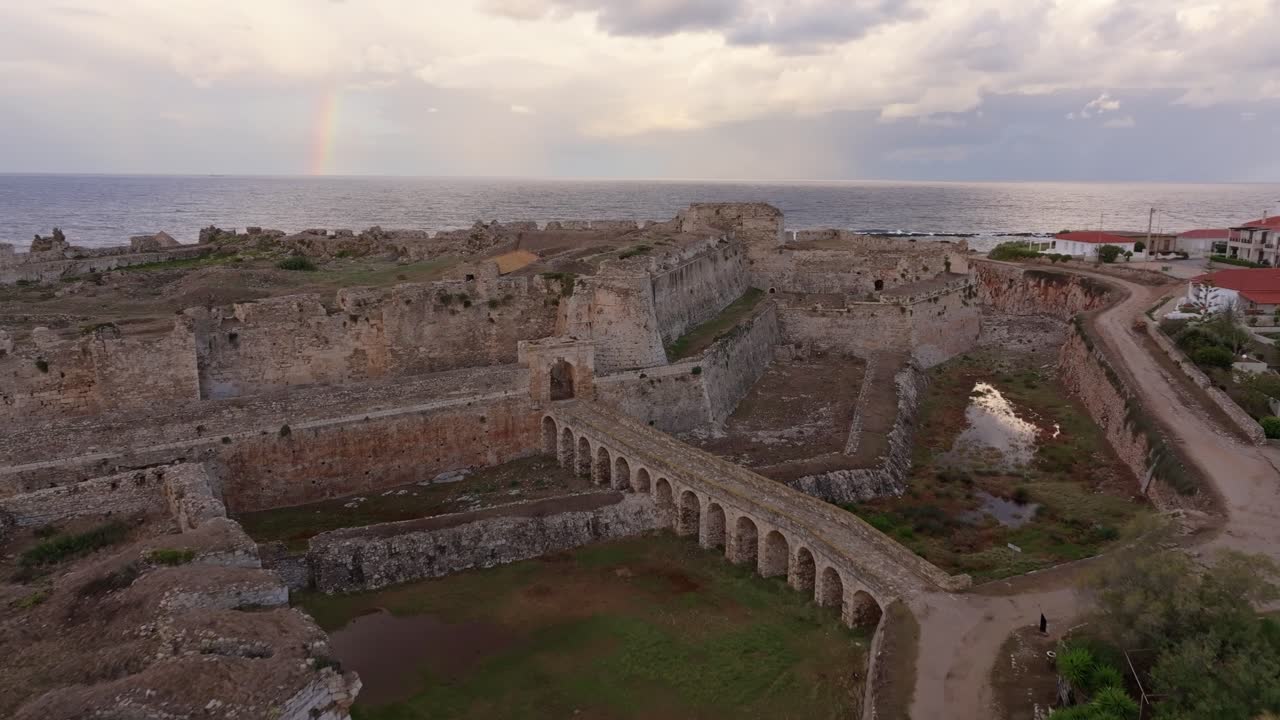 Vista aérea do nascer do sol iluminando o Castelo de Methoni à beira-mar