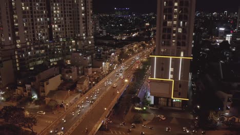 aerial orbit view across busy traffic bridge and underpass at night